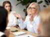 Frau gestikuliert in einem Meeting