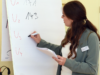 Eine Frau schreibt etwas auf ein Flipchart