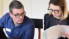 Mann und Frau schauen auf ihre Notizen