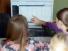 Eine Frau zeigt auf den Bildschirm eines Computers