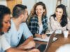 Studierende sitzen an einem Tisch und arbeiten gemeinsam