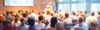 Viele Personen sitzen im Plenum und hören sich einen Vortrag an