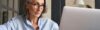 Eine Frau mit Brille schaut auf den Bildschirm ihres Computers
