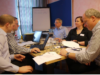 Ein Team sitzt gemeinsam an einem Tisch und arbeitet