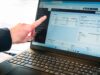 Eine Hand zeigt auf Kennzahlen auf einem Laptop